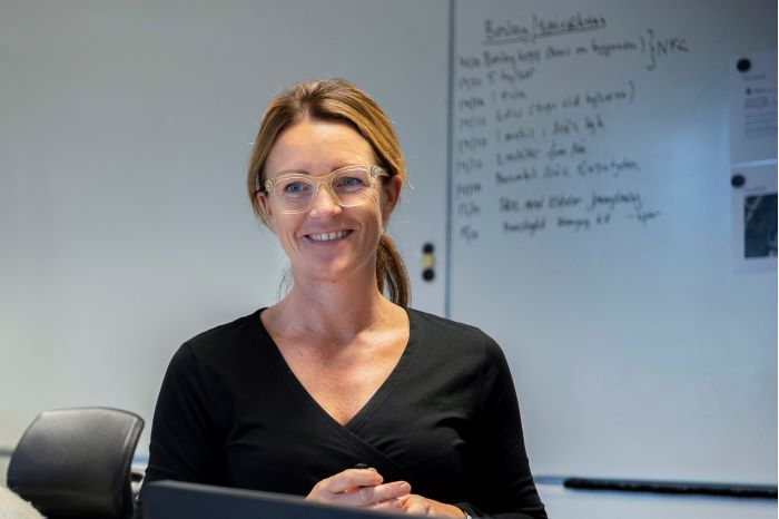 Anna Bergkvist står framför en whiteboard. Foto.