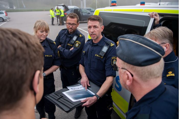 Tf gruppchef Andreas Mjörnestål håller i utsättning utomhus med poliserna som deltar i insatsen. Foto.