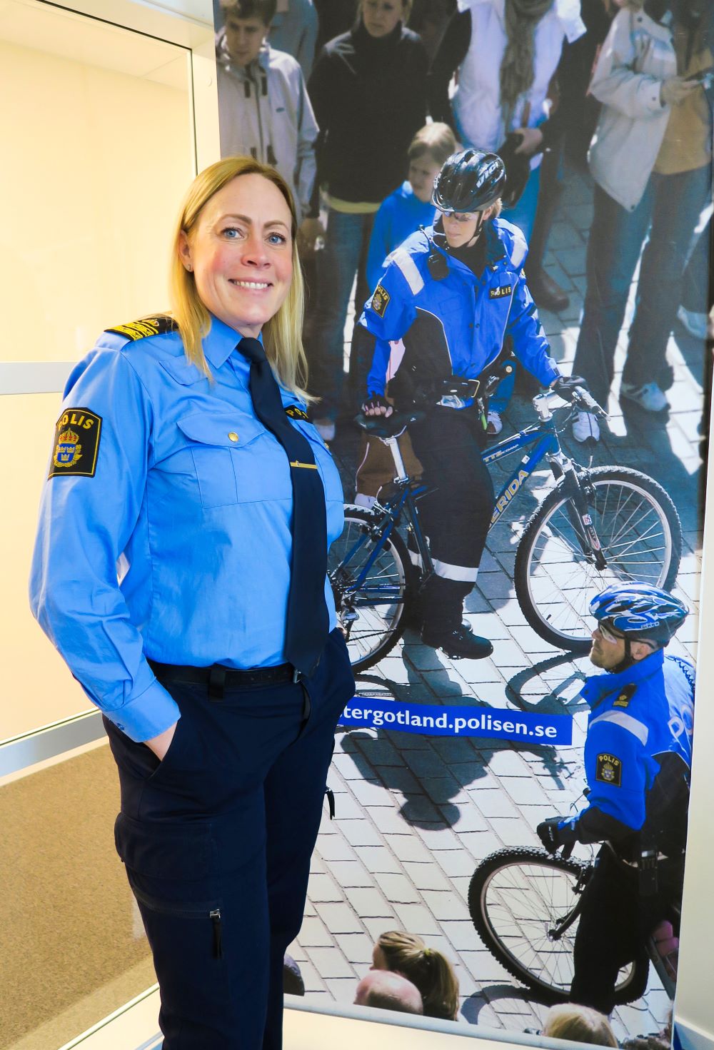Kvinna i polisuniform bredvid en bild med cyklister