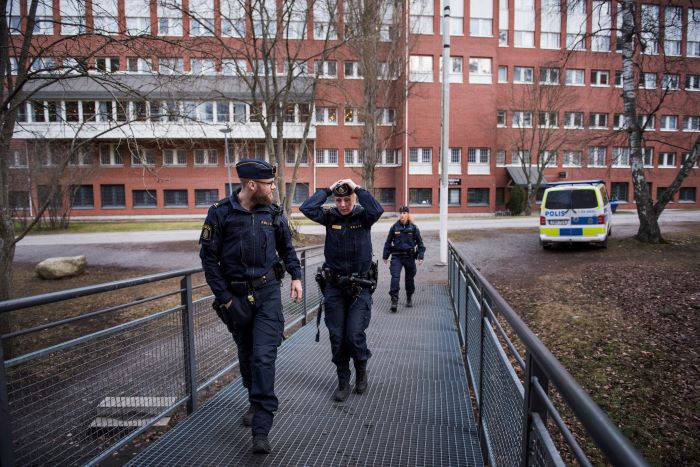 Tre poliser på väg in i en skola