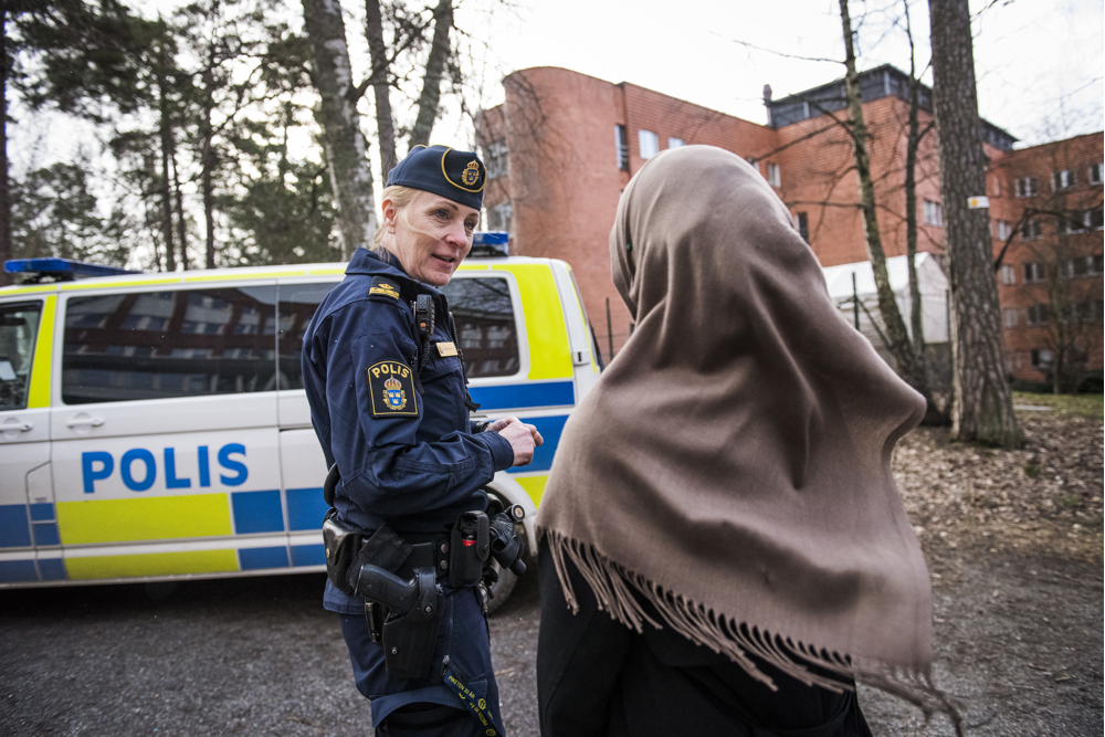 Polis pratar med en tjej utanför en skol