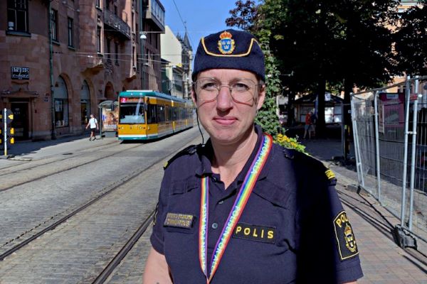 Kommunpolisen Annika Granath står i stadsmiljö där en spårvagn syns i bakgrunden. Foto.