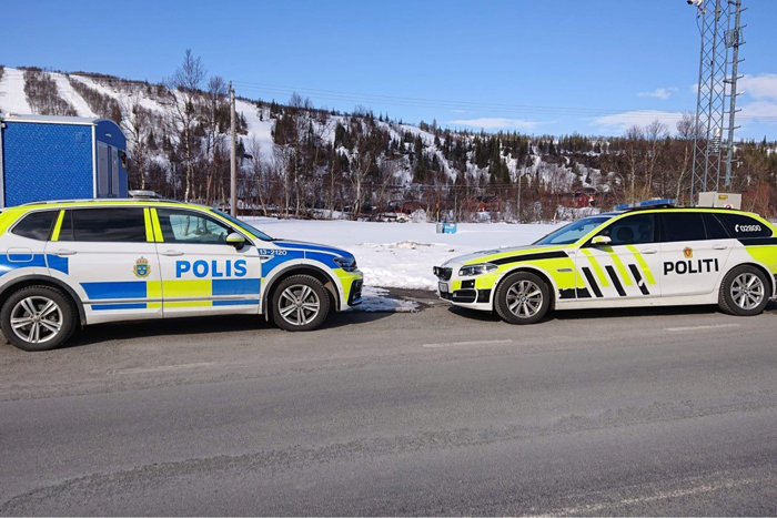 En svensk och en norsk polisbil står mot varandra. Foto.