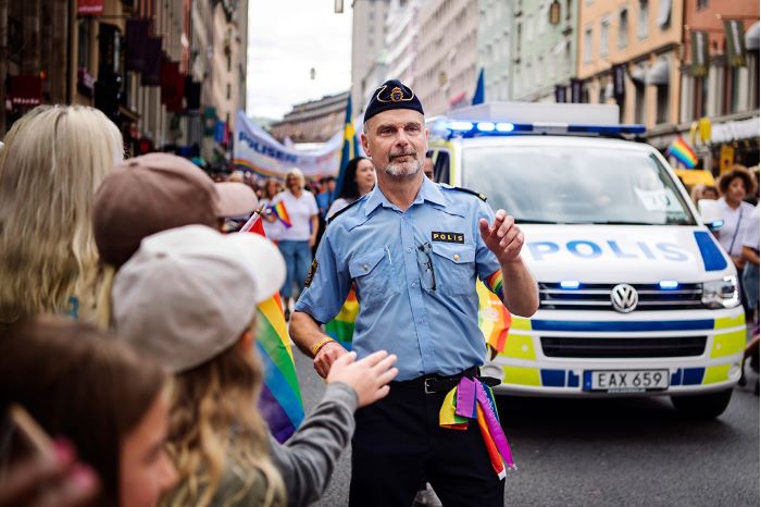 Göran Stanton i Prideparad framför en polisbuss. Foto.