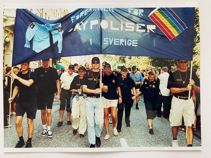 Göran Stanton och kollegor i Prideparaden med en banderoll som de håller över huvudena. Foto.