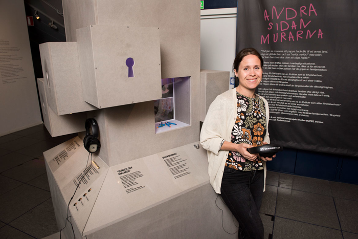 Tina Landgren framför utställningsmontrar på Polismuseet.