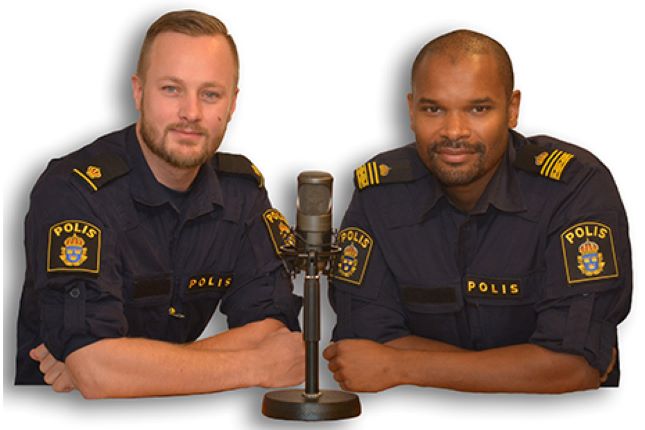 Linus Malm och Benjamin Prom i sina polisuniformer framför mikrofonen. Foto.