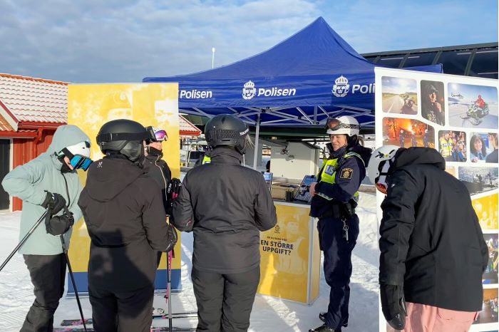 Isabel Ornby står vid en utställningsmonter utomhus och pratar med människor. Foto.