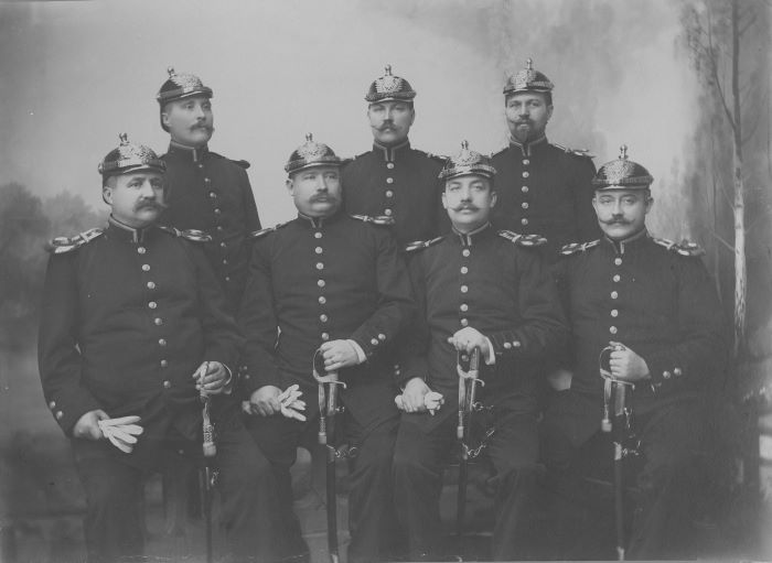 Sju konstaplar i polisuniform med polissabel, från tidigt 1900-tal. Foto.