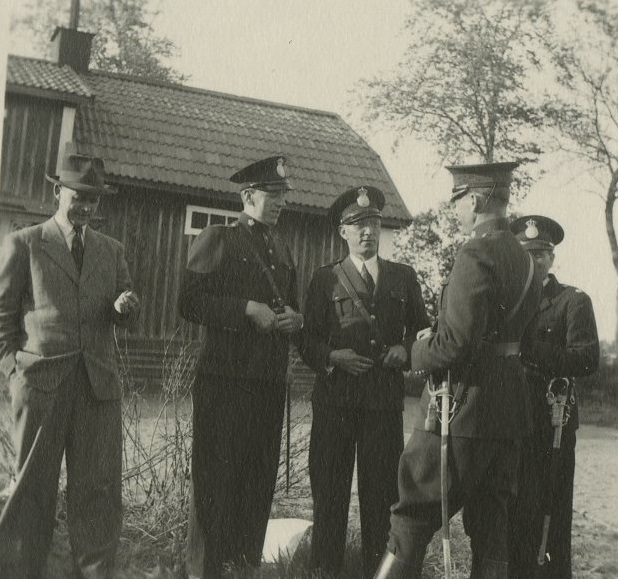 Fem uniformerade poliser i utomhus i slutet av 1940-talet. Foto.