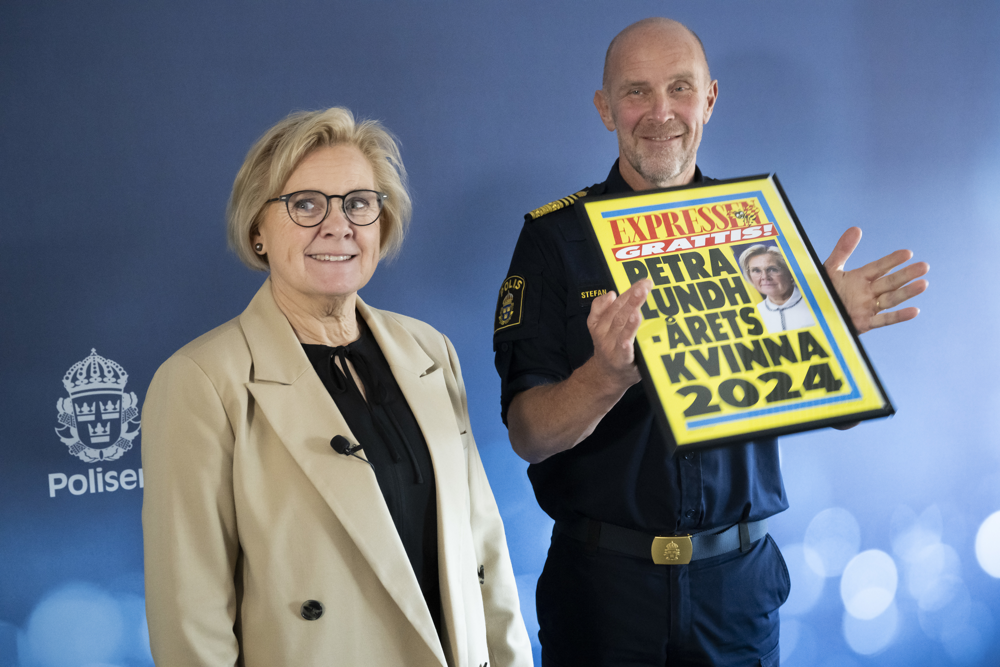 Petra Lundh och Stefan Hector står bredvid varandra och Stefan håller i en inramad löpsedel från Expressen på Petra Lundh som årets kvinna. Foto.