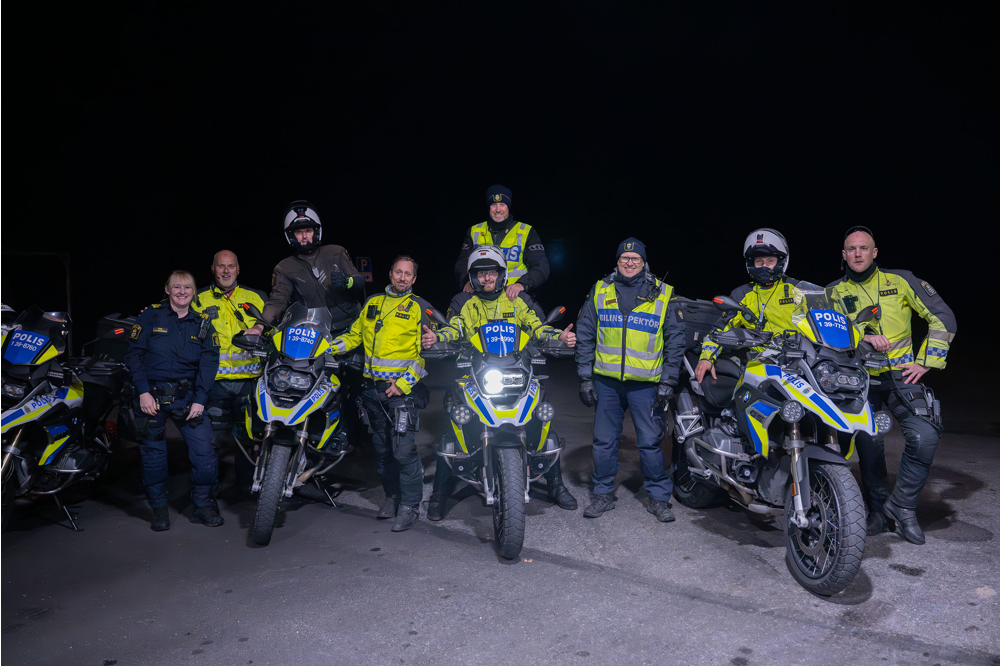 Ett glatt gäng poliser står uppradade, några på motorcyklar. Foto.
