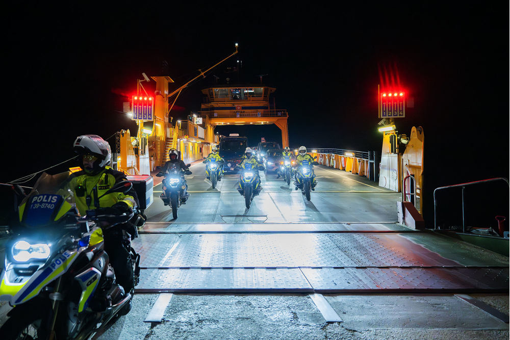 Fler poliser på motorcyklar åker av en färja mot land. Foto.