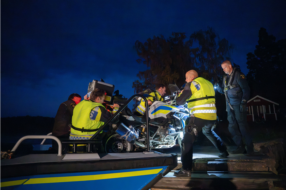 Polismotorcyklar lyfts av sjöpolisens båt. Foto.