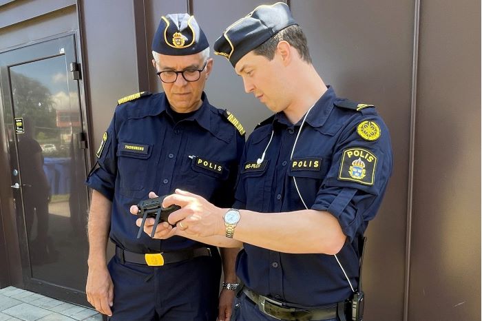 UAS-piloten Linus Karlsson visar rikspolischef Anders Thornberg hur man styr en UAS. Foto.