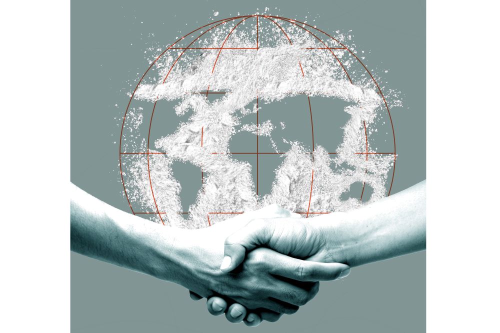 Ett handslag med två händer ses framför en kontur av en jordglob med vitt narkotikapulver utstrött över globen. Illustration.