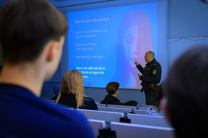 Richard Hedström, områdespolis LPO Enköping/Håbo, föreläser för åttaklassare i en aula. Foto.