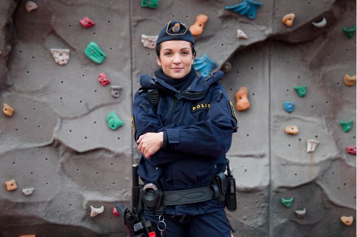 Polisen Alexandra Goncalves står med armarna i kors framför en klättervägg