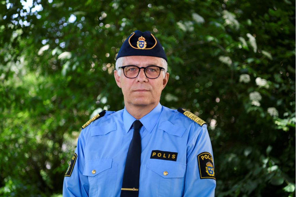 Rikspolischef Anders Thornberg med grönska i bakgrunden. Foto.