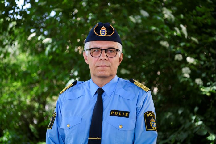 Rikspolischef Anders Thornberg med grönska i bakgrunden. Foto.