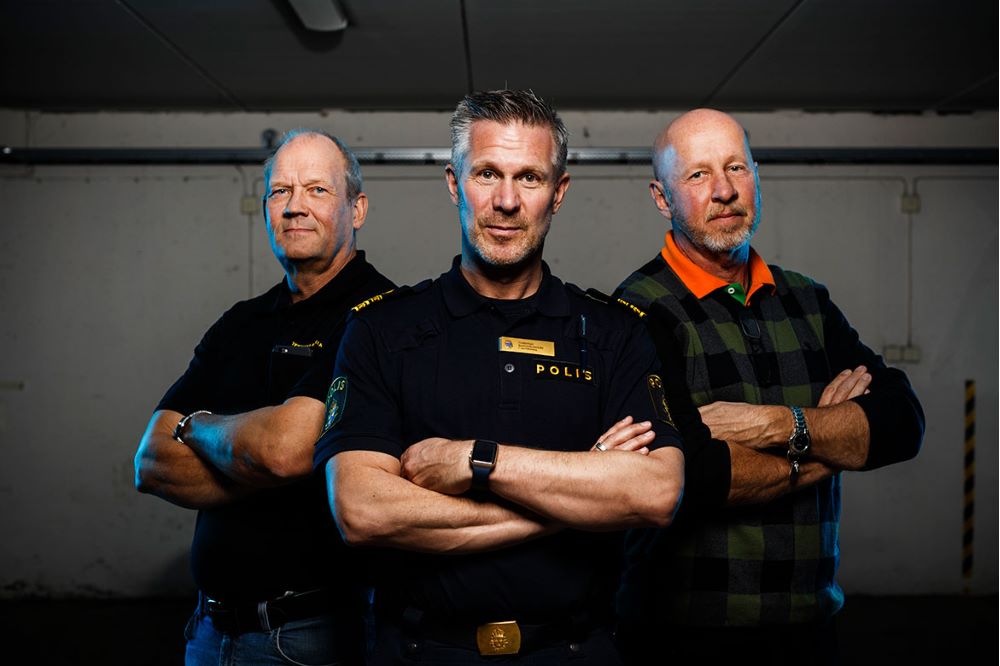 Poliserna Göran Aidemark, Christer Bartholdsson och Karl-Göran Saxerbo står sida vid sida i ett garage, med armarna i kors.