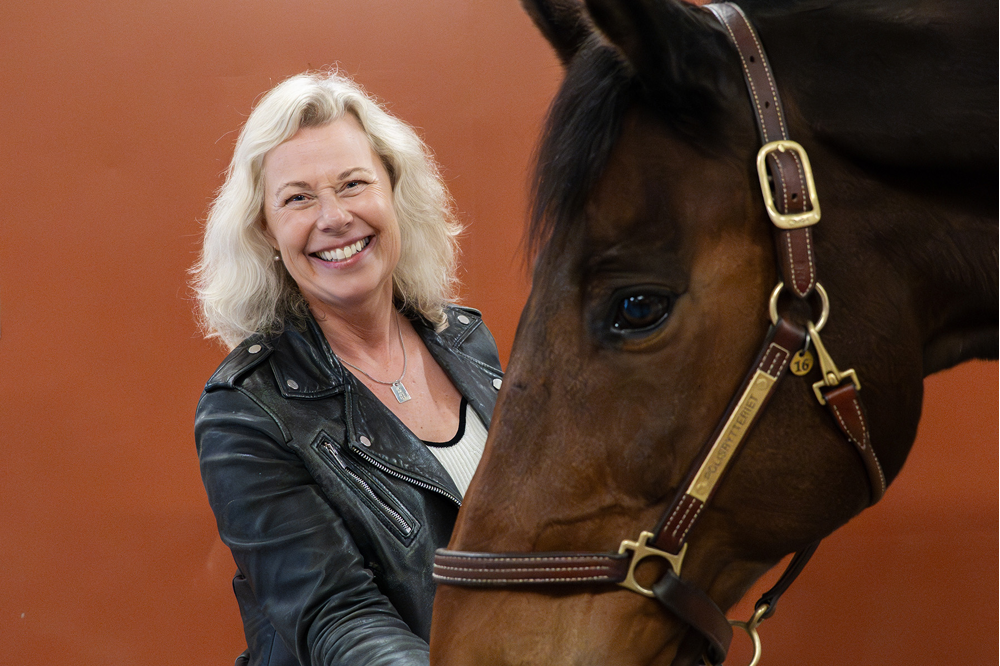 Charlotte Hemvik matar en häst. Foto.