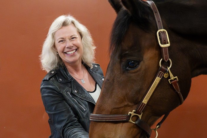 Charlotte Hemvik matar en häst. Foto.