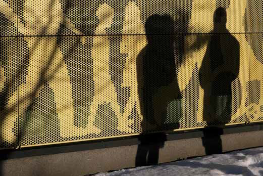 Två svarta siluetter av människor ses framför ett myller av gula siluetter av människor. Illustration.