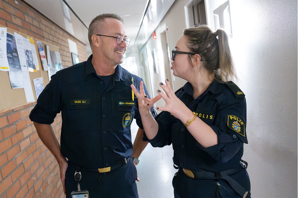 Glenn pratar med Emelie Torstensson i korridoren. Foto.