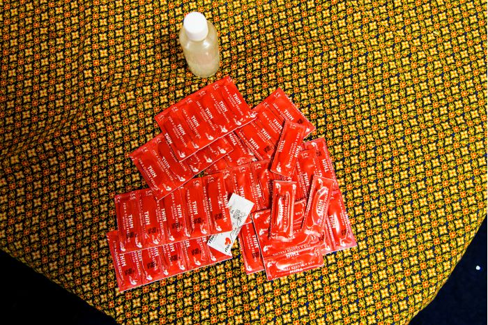 Kondomer och glidmedel är utlagda på ett tygstycke. Foto.