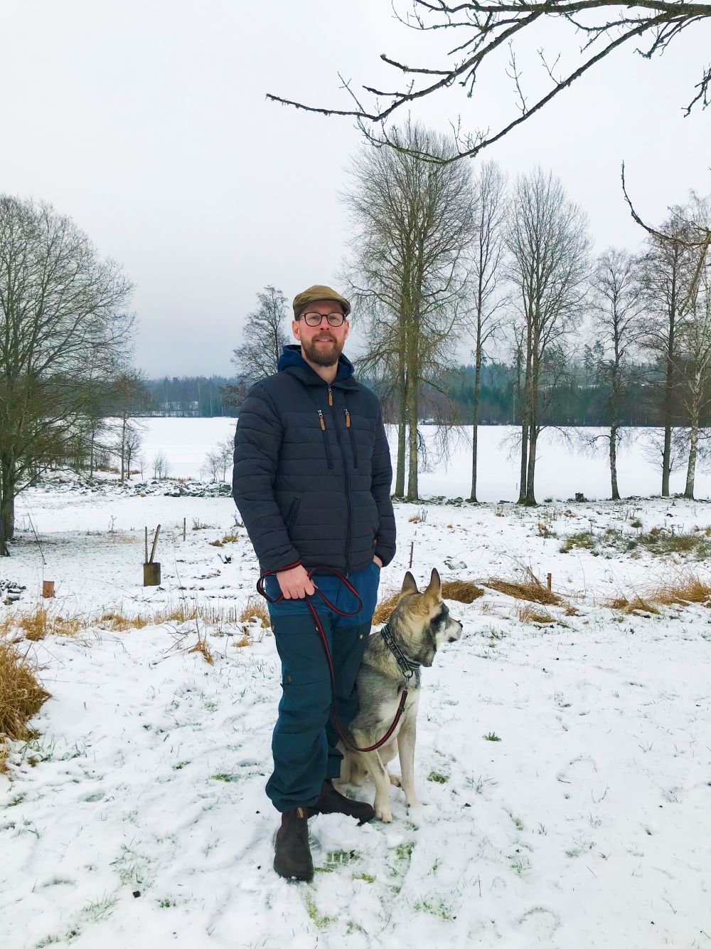Man med hund i vintrigt landskap
