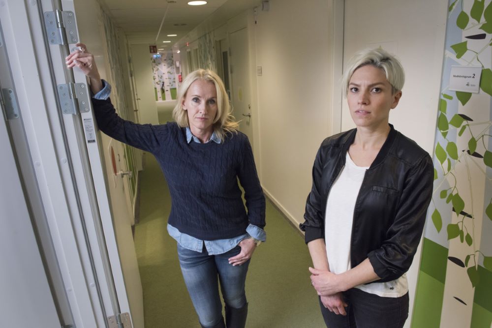 Maria Gorosch och Annie Godin står i en korridor på ett kontor och tittar mot kameran