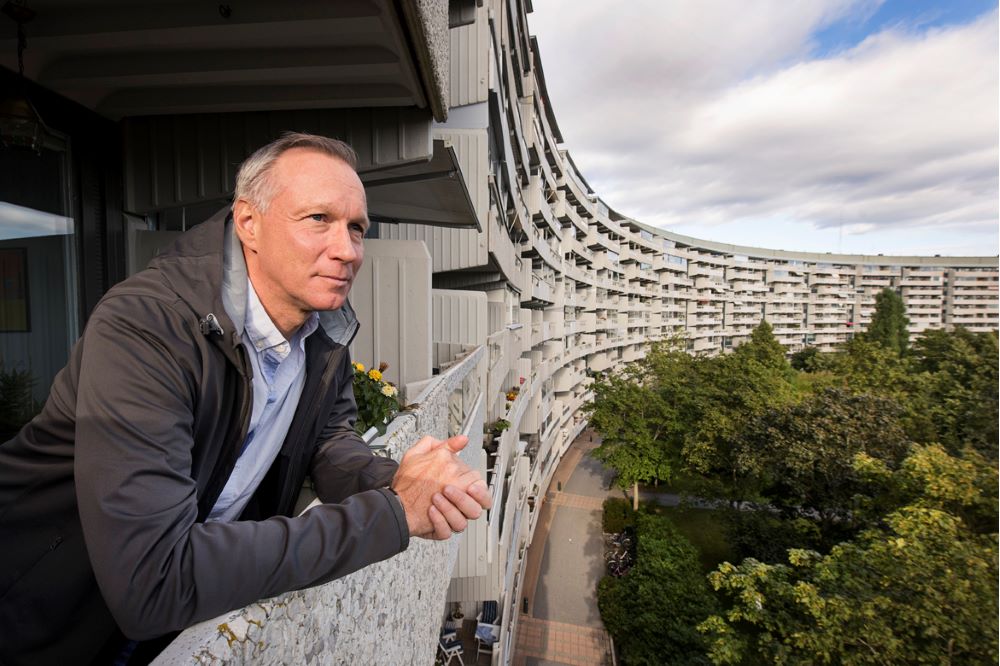 Analytikern Jonas Hildeby tittar ut över ett bostadsområde från en lägenhetsbalkong.