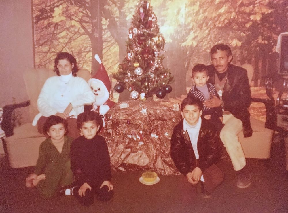 Ayman Aboulaich tillsammans med sina föräldrar och syskon framför en julgran. Foto.
