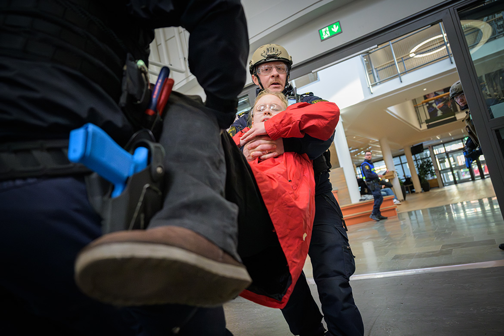 Områdespolisen Jonas hjälper till att bära ut en ”skottskadad” student till uppsamlingsplatsen för skadade. Foto.