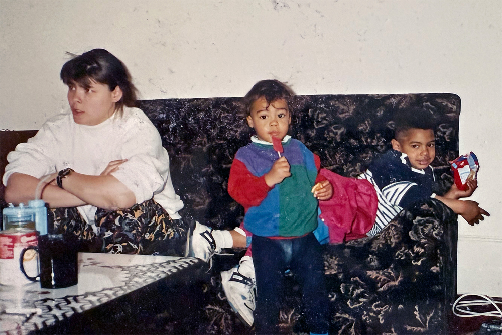 Patrick Tornéus som liten vid soffan i vardagsrummet mellan sin mamma och storebror. Foto.