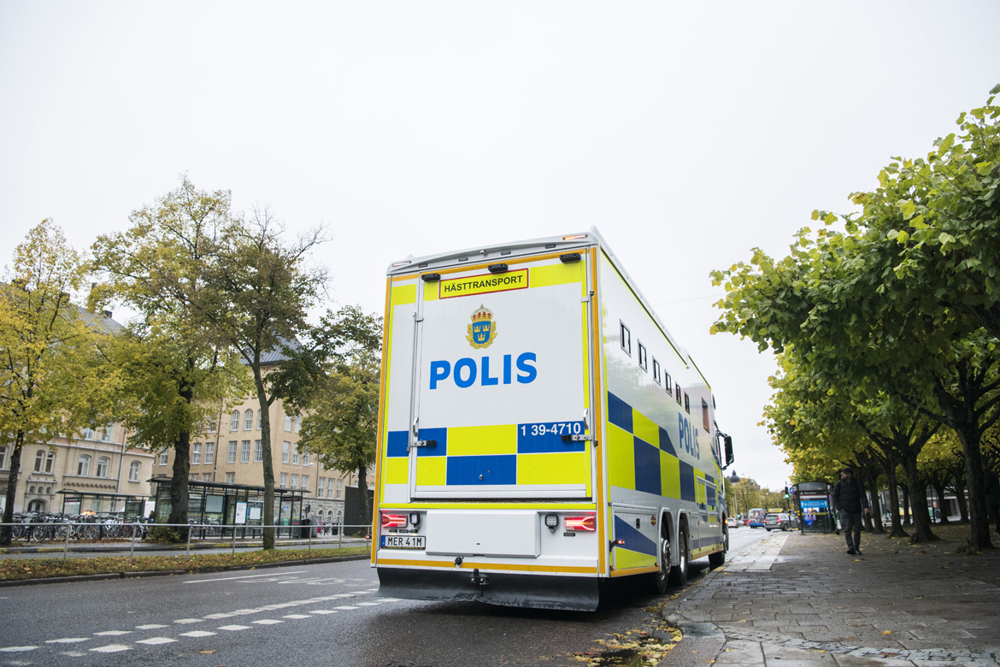 Polisrytteriets lastbil sedd snett bakifrån på en väg. Foto.