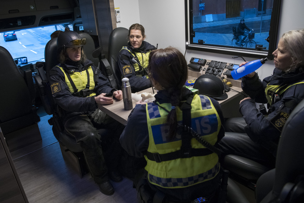 Fyra polisryttare sitter vid ett bord i pentryt. Foto.