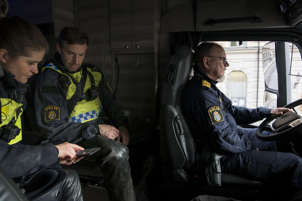 Två polisryttare sitter på passagerarplatserna i lastbilen bakom kommissarie Anders ”Jasse” Jansson. Foto.