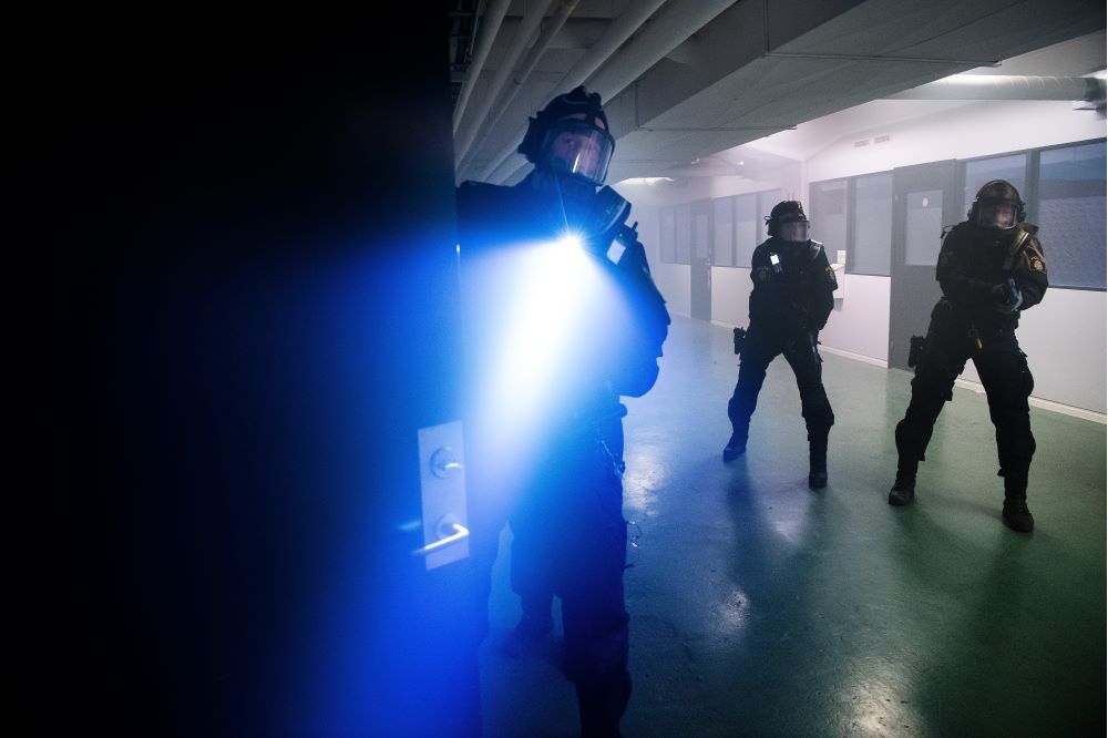 En patrull på tre personer går genom en korridor. Foto.