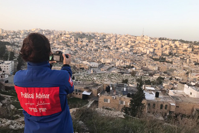 Sofia Zitouni står med ryggen mot kameran och tar själv en bild på utsikten över staden Hebron. Foto.