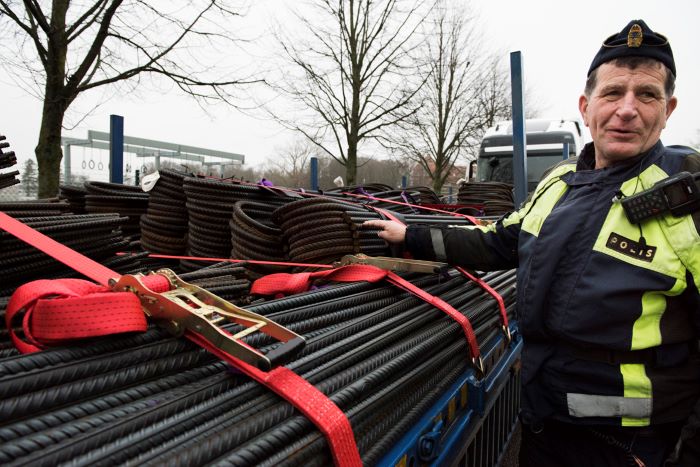 Trafikpolisen Sören Johansson framför ett lass med järnrör. Foto.