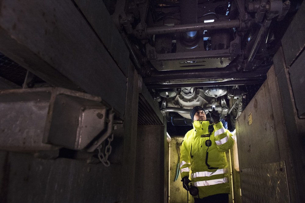 Bilinspektör Mazen Al-Asam inspekterar underredet på en lastbil från en grop. Foto.