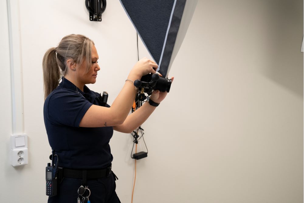 Arrestvakten Johanna Olsson håller i en kamera. Foto.