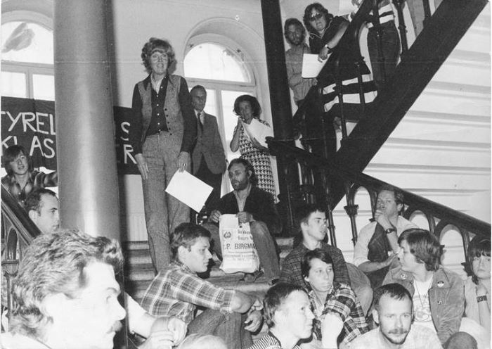 Flera demonstranter sitter i en trappa. Foto.