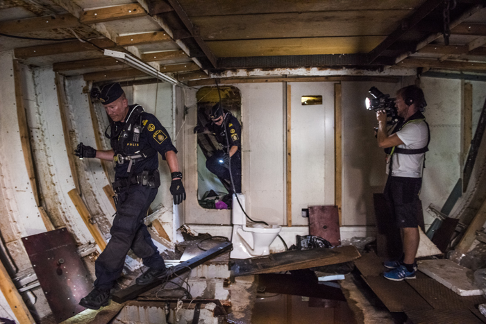 Sjöpoliserna nere i skrovet på ett lastfartyg. Foto.