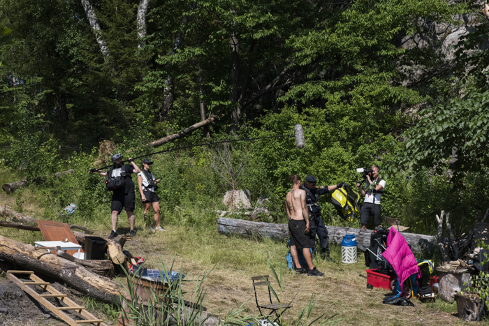 Tv-teamet filmar när sjöpolisen Miklas Sjönell undersöker en sov- och rastplats på stranden. Foto.