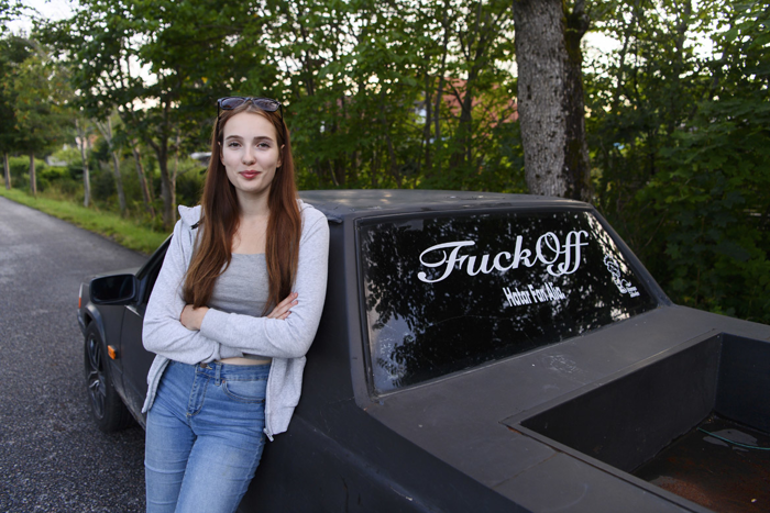 Marina Springer står lutad mot sidan av sin a-traktor. Foto.